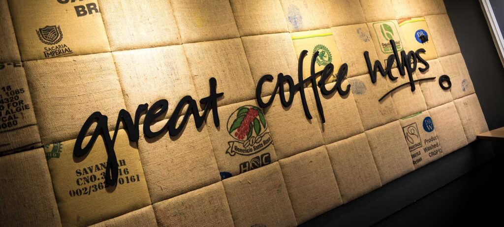‘Great coffee helps’ slogan on a recycled background at Esquires Coffee