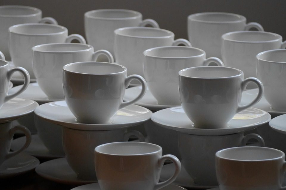 White coffee cups and saucers stacked on top of each other