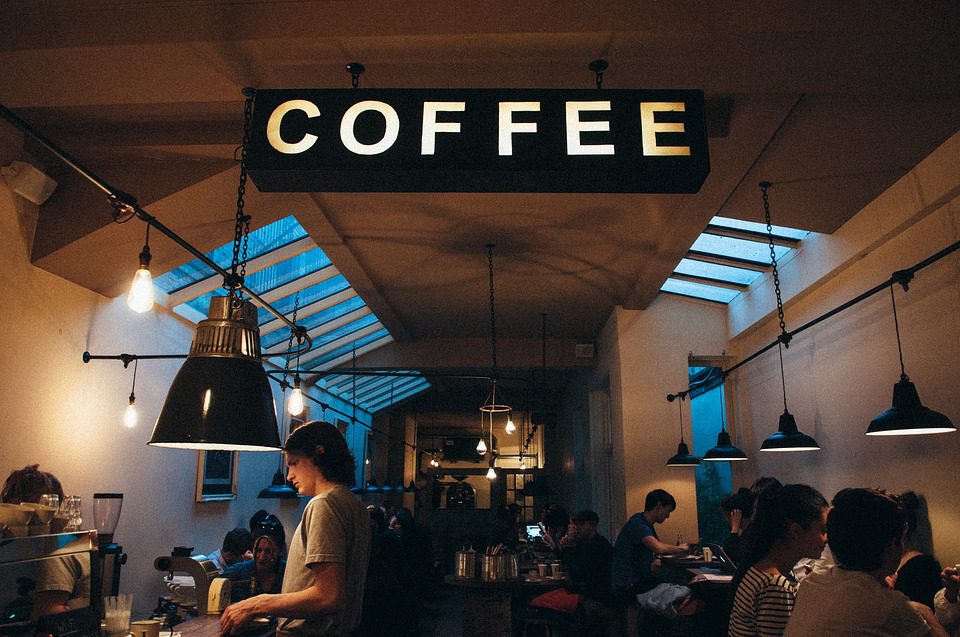 A warm coffee shop with a large sign above