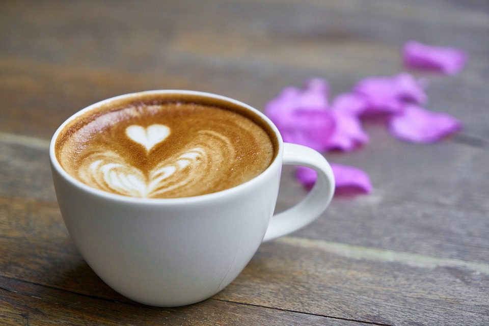 A latte with heart design and petals