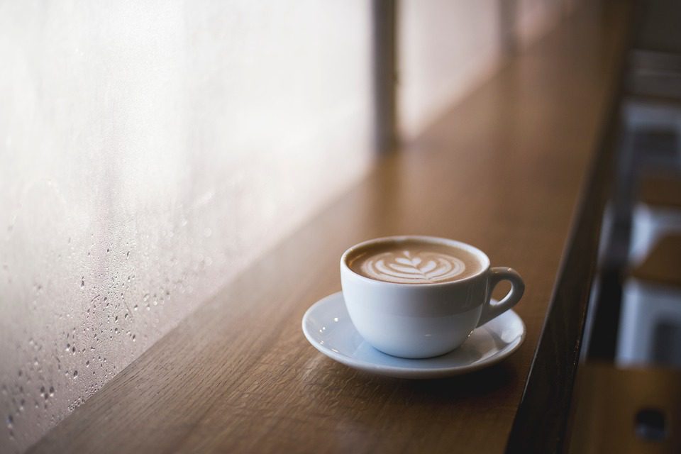 A cup of coffee by a window on a rainy day