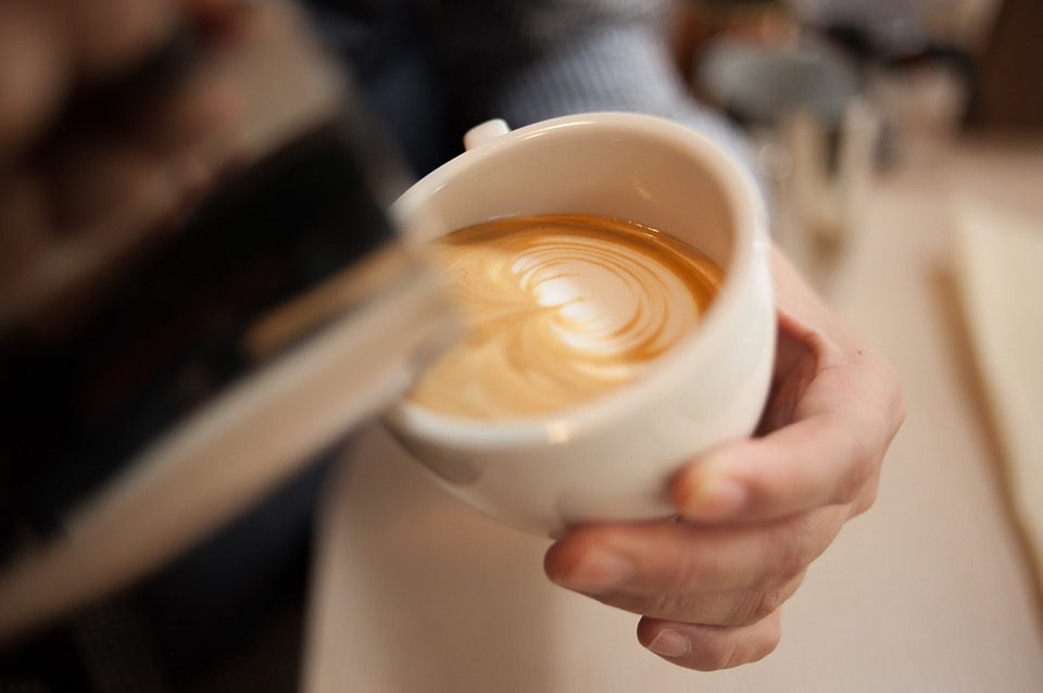 A barista pouring a latte