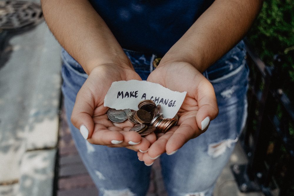 A person holding money and saying make a change