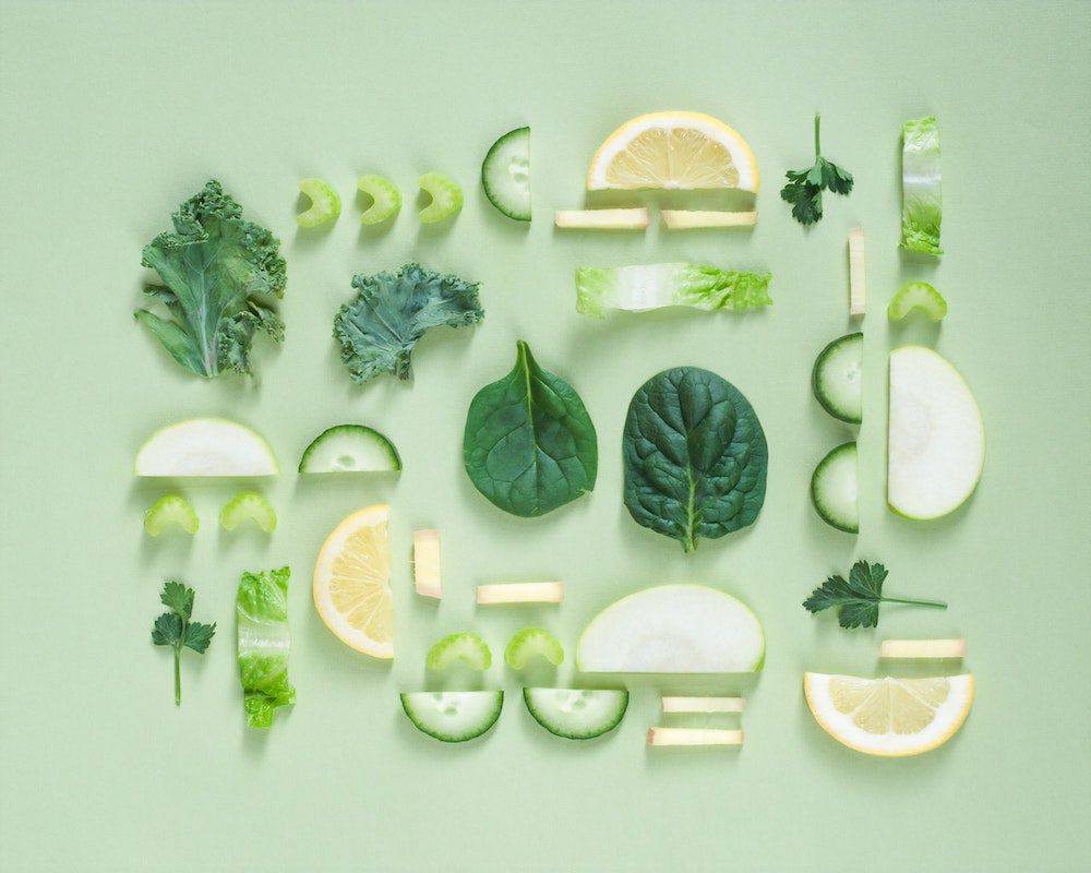 a pattern of lemons, spinach, cucumber and green salad