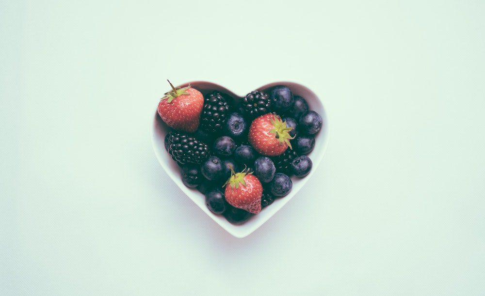 heart shaped bowl of blueberries, strawberries and blackberries 