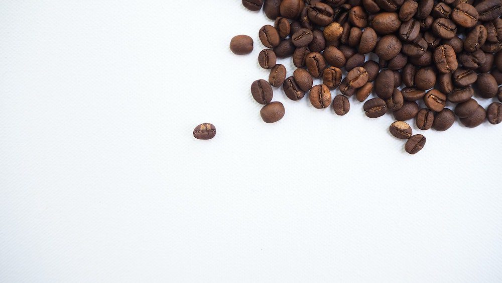 Coffee beans on a white surface

