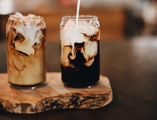 Two iced coffees on a wooden board