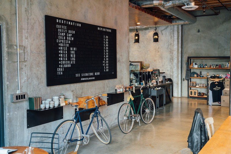 The interior of a coffee shop with bicycles leaning on the wall