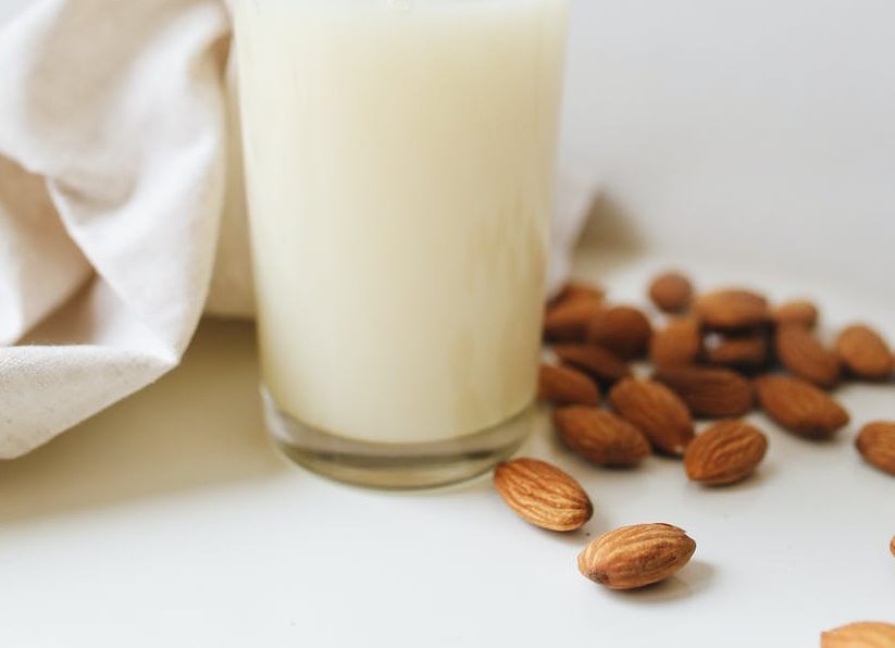 Almonds beside a glass of almond milk 