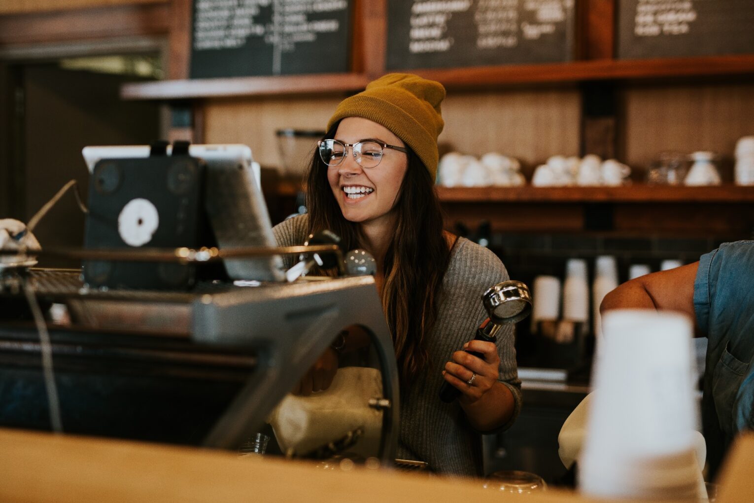 A barista smiling while making coffee