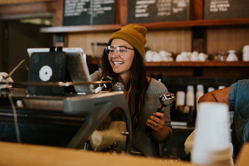 A smiling barista making coffee