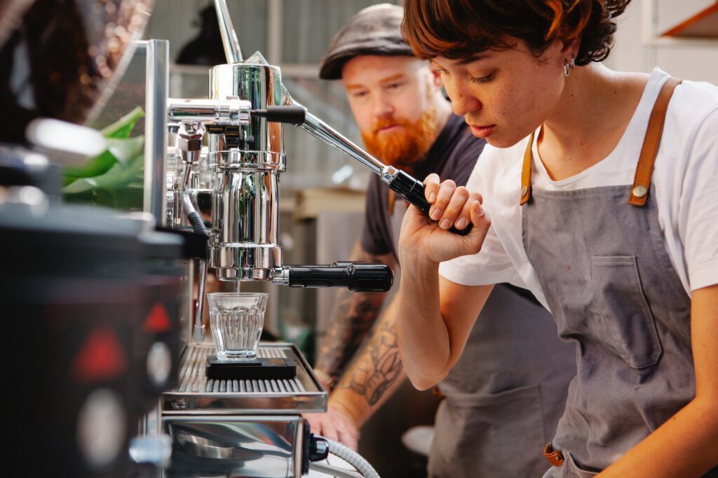 Barista pulling lever of manual coffee machine