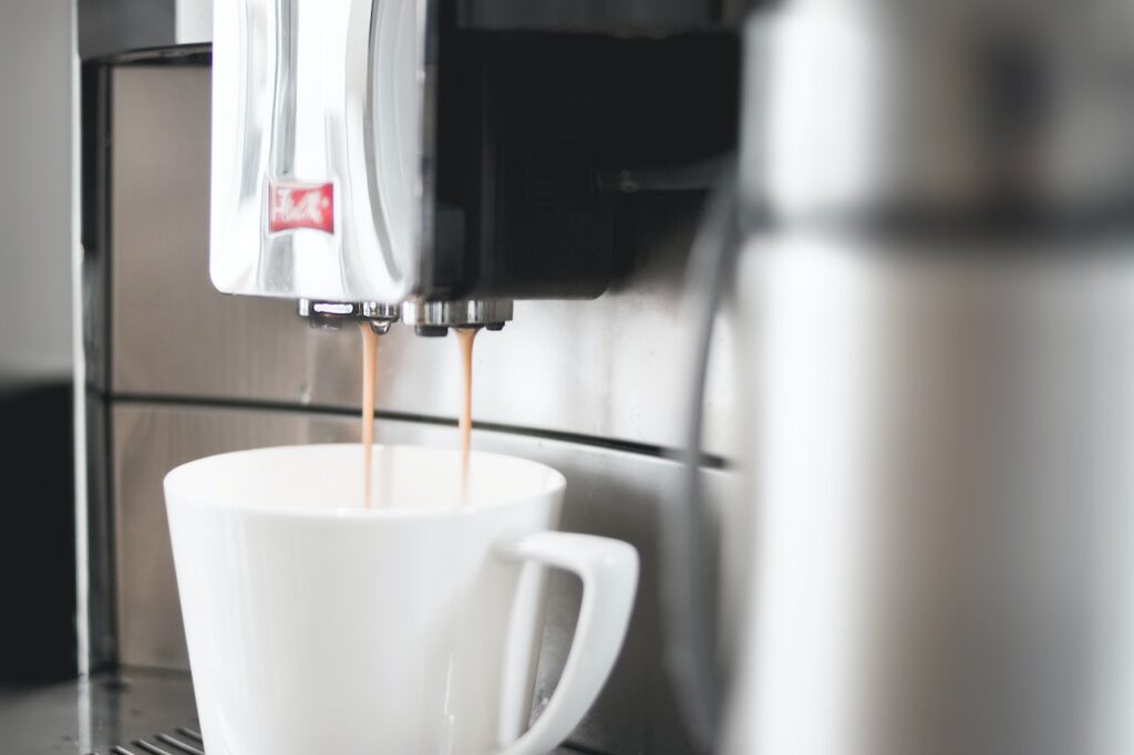 Coffee pouring into mug from automatic espresso machine