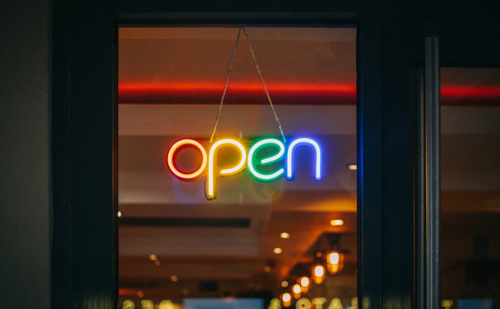 A colourful neon open sign on a door