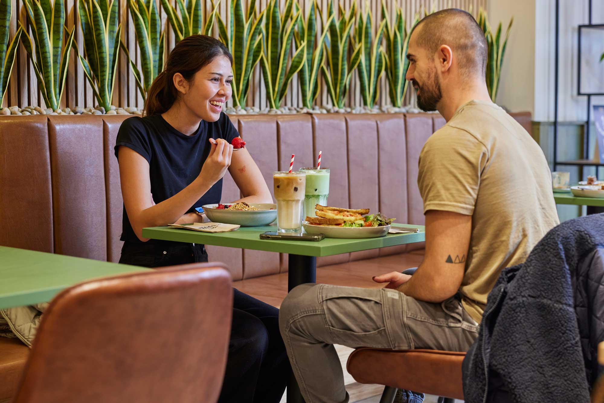Two people enjoying food and drink at an Esquires store