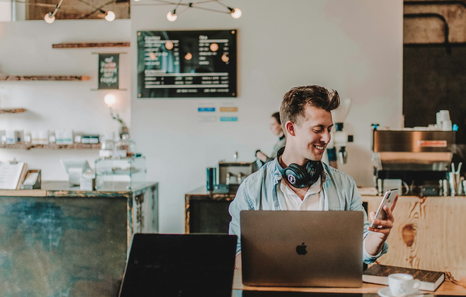 Person with a laptop and phone in a coffee shop 