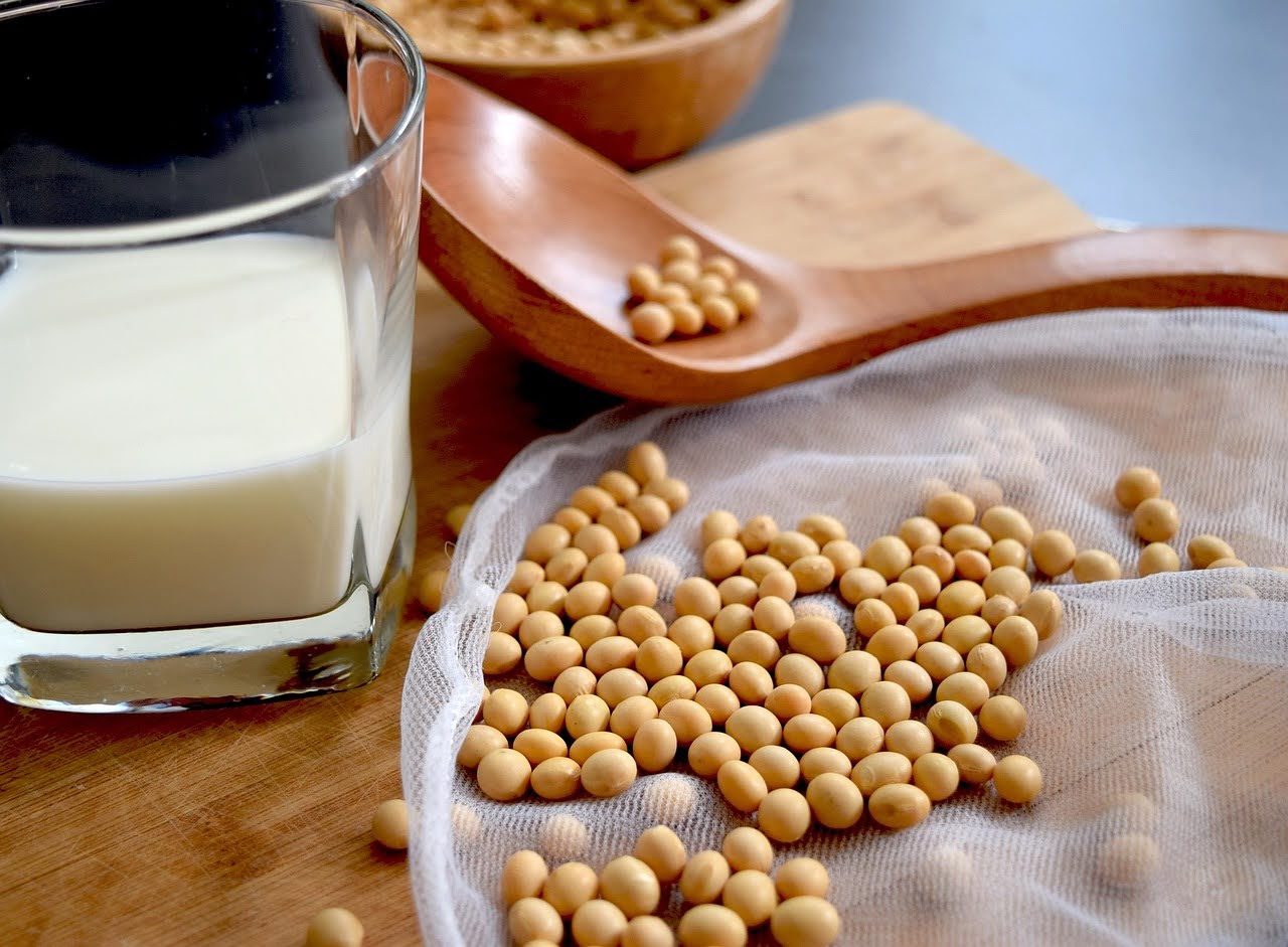 Soy milk and soy beans with a wooden spoon